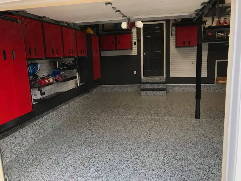 Garage floor with Domino torginol color flakes and red garage cabinets by Grasso Services